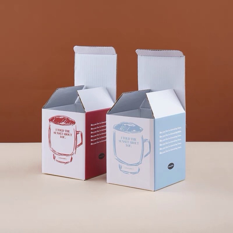 Stylish red and blue mug packaging boxes with open tops and printed designs.