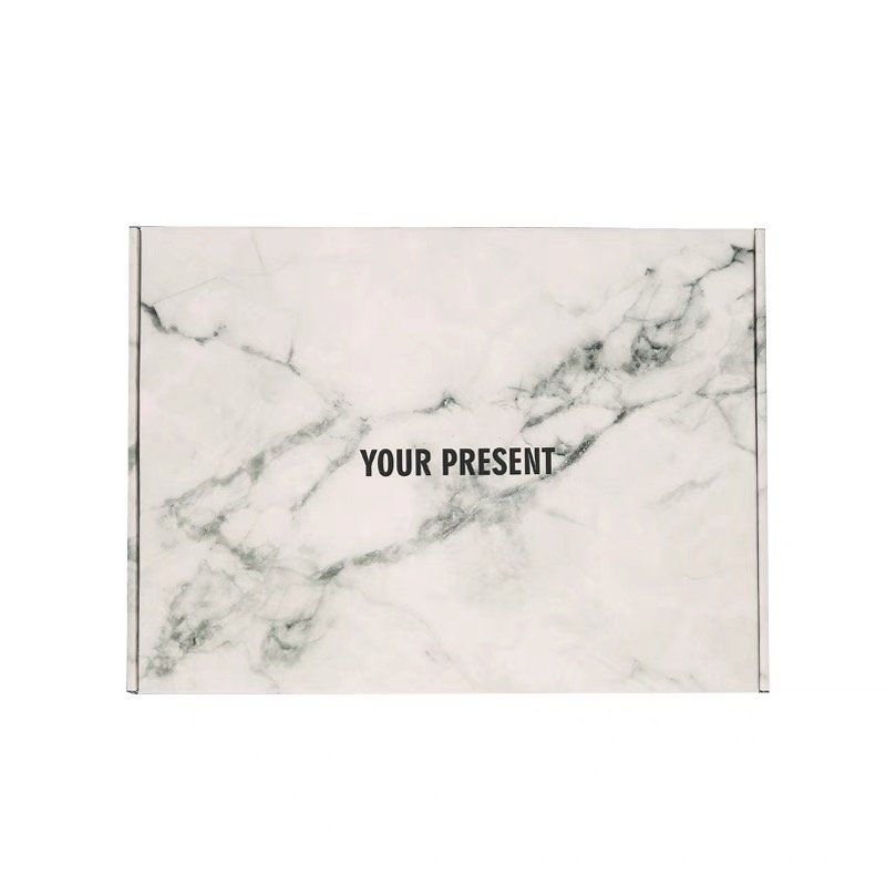 White marble-patterned gift box lid with "Your Present" text.