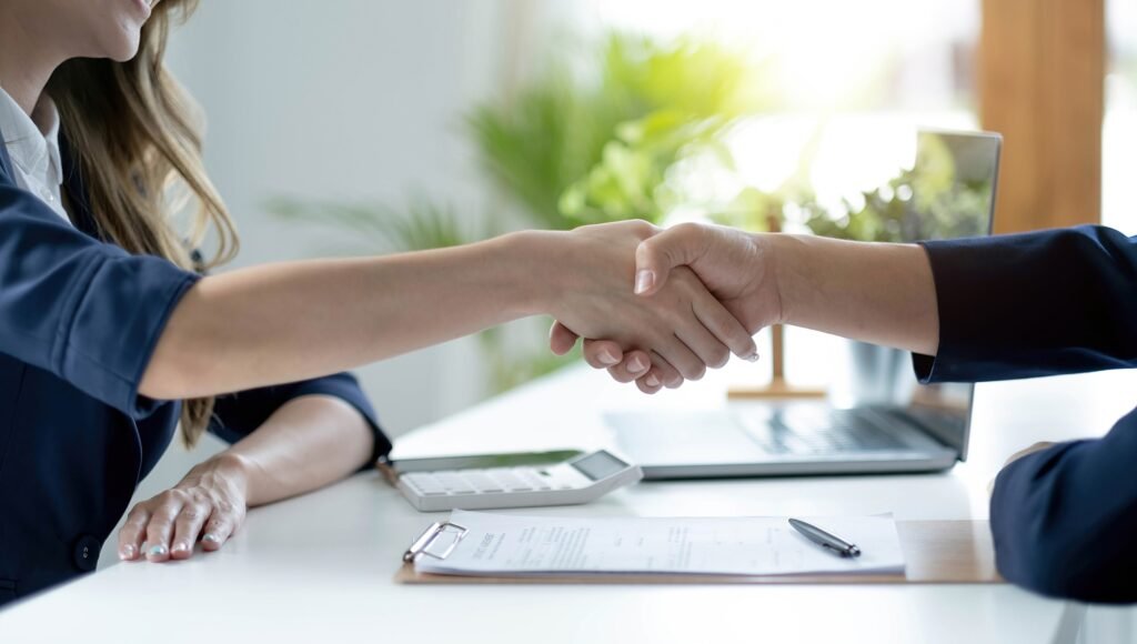 Two individuals shaking hands in a gesture of successful collaboration and partnership.