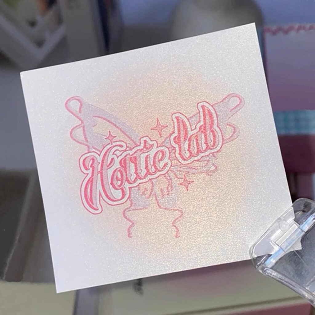 Square card with pink butterfly and "Hottie Lab" text on a shimmery surface.